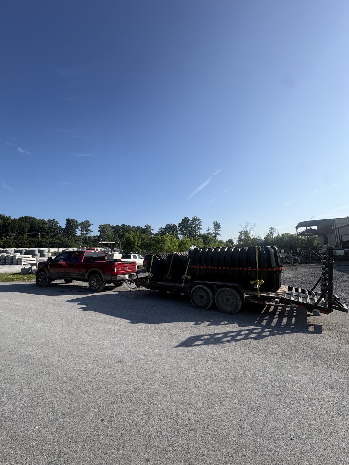 Truck and trailer hauling septic tanks to the job site